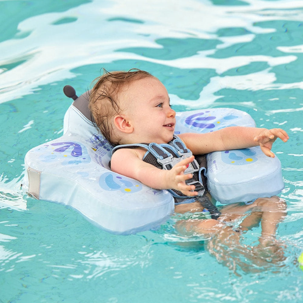 Infant in the Mambobaby Butterfly float practicing breaststroke in a luxury pool using the 40-degree safety angle.